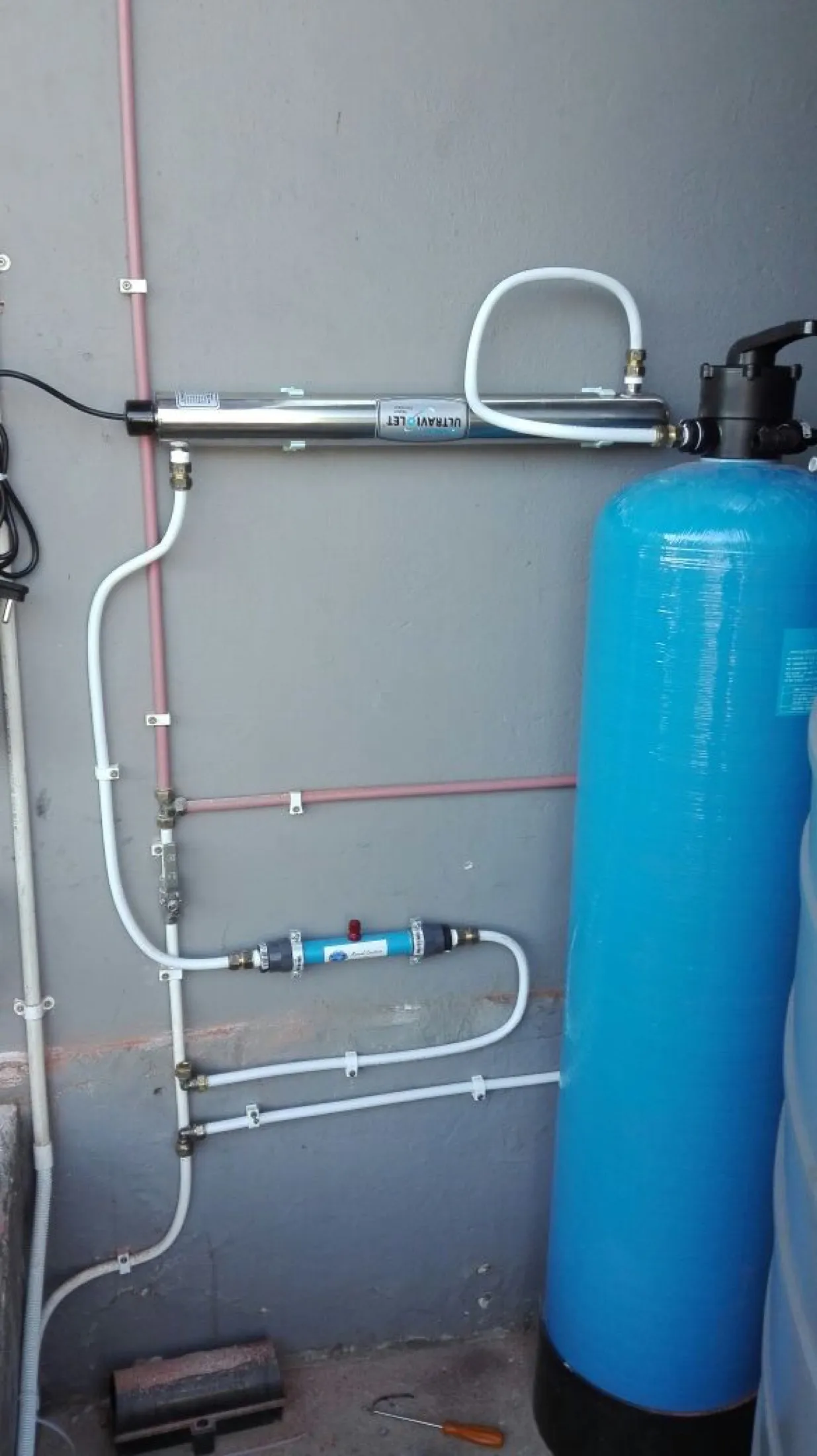Conditioner and filter vessel mounted against a wall with pipework
