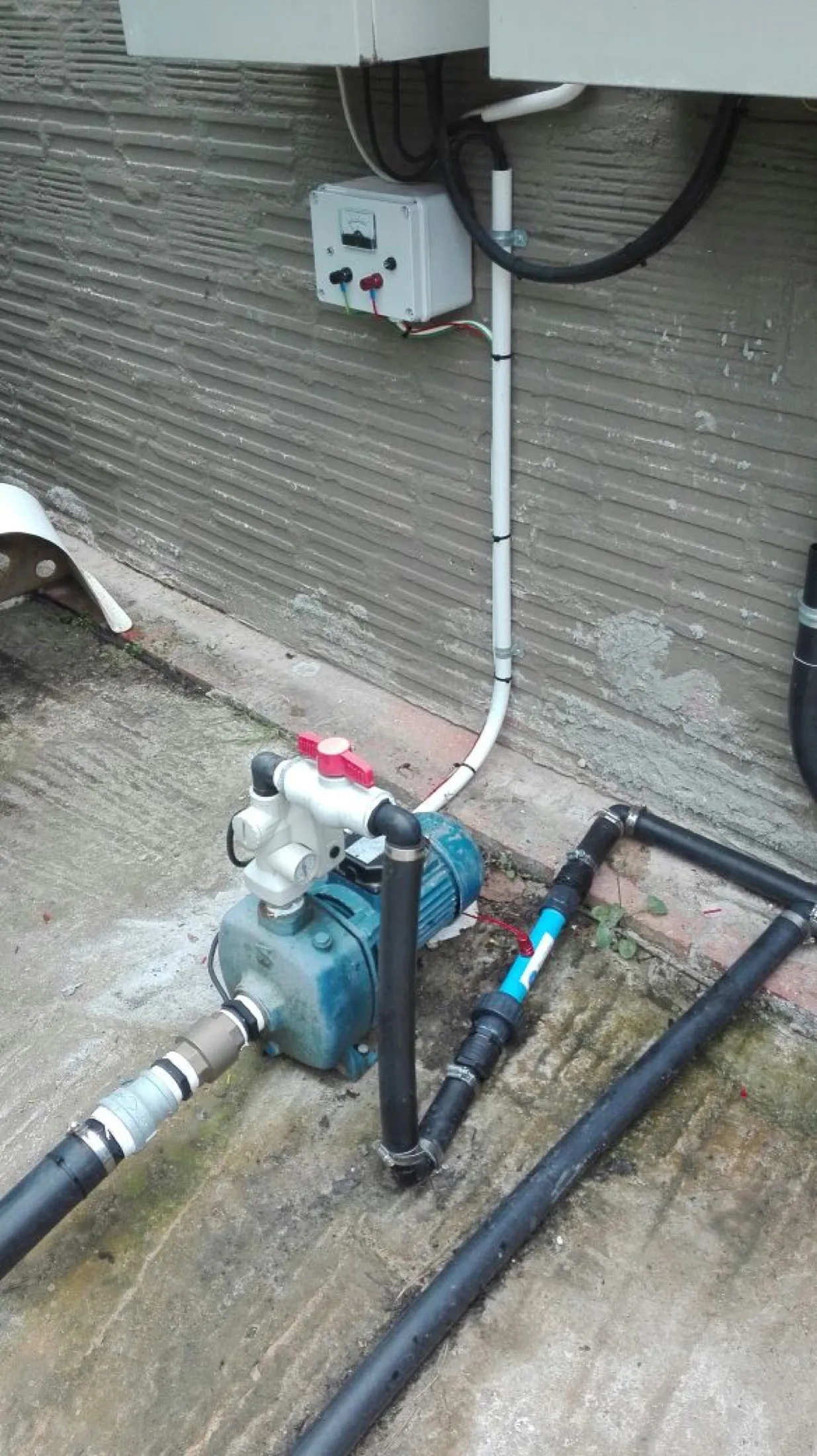 Pump installation with weatherproof power point on a wall