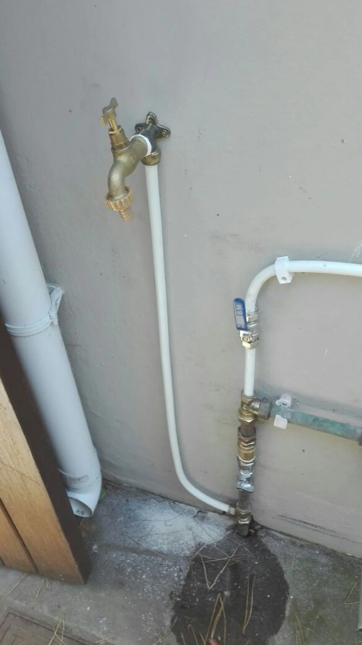 Outdoor tap and copper pipework on a wall after installation